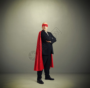 穿着红色面罩和浅灰色背面披风的超级英雄般的高级背景图片