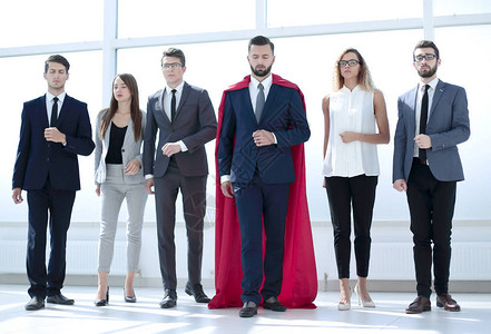 身穿红色超级英雄斗篷的商人和他的商业团队照片背景图片