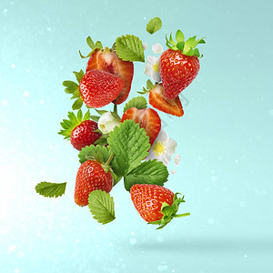 飞行新鲜美味成熟草莓与绿叶在浅蓝色背景食品悬浮概念创意食物布局图片