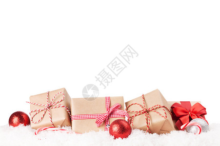 圣诞礼物盒和雪中的装饰品图片