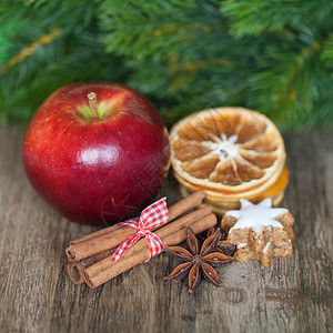 苹果与香料和干柠檬片在木头上的特写镜头图片