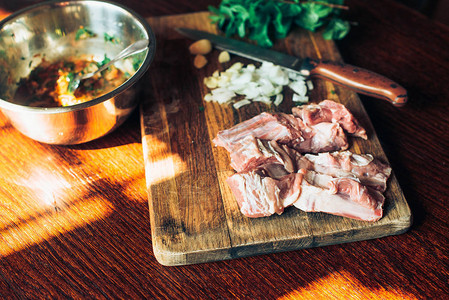 生鲜羊肉排骨和木制背景上的调味料图片