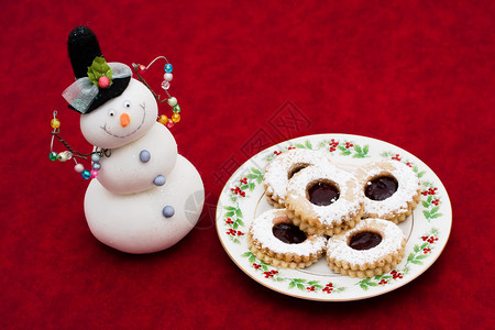 一盘糖饼干和一个红背景的雪人红图片
