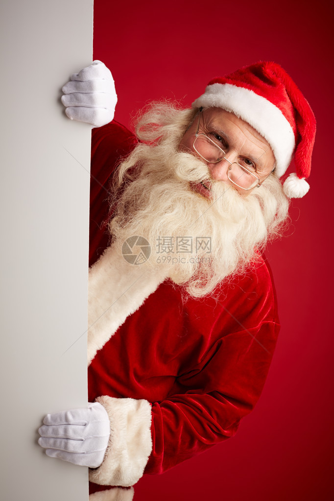 圣诞老人在红色背景的空白广告牌上图片