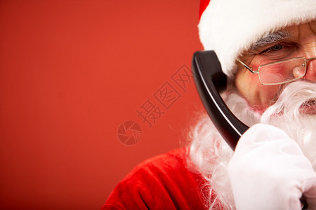 快乐的圣诞老人通过电话交流的照片图片