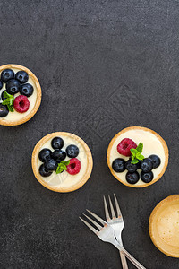石板背景上覆盆子和蓝莓的美味馅饼图片