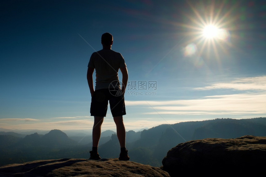 独自一人穿黑裤子的徒步旅行者站在岩石帝国上图片