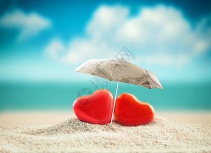 夏日海滩伞下的两颗心情人节背景图片