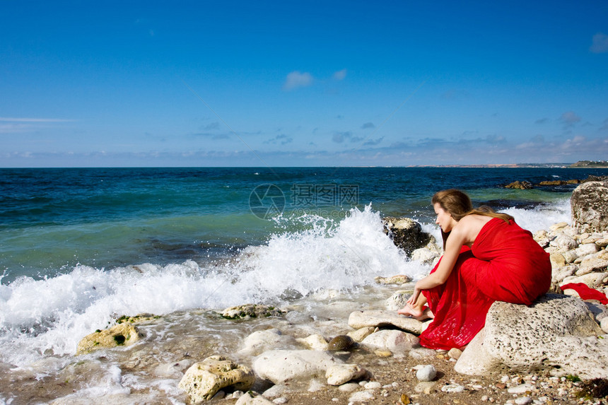 海边沙滩上穿红裙子的美女图片