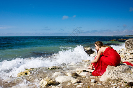 海边沙滩上穿红裙子的美女背景图片