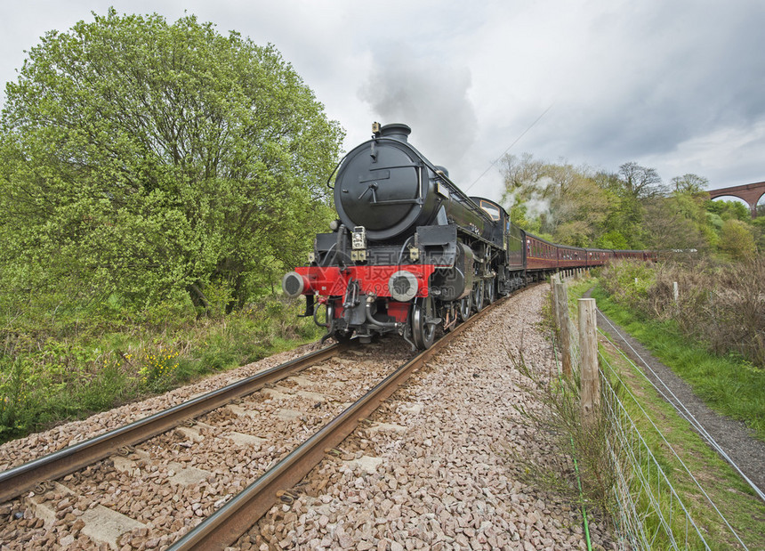 旧的英语蒸汽车沿铁轨穿过农村风景图片