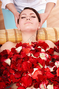 穿玫瑰花瓣浴缸的漂亮女背景图片