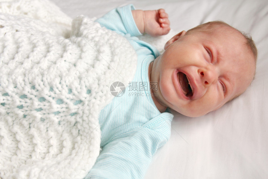 一个可爱的一个月大的新生儿躺在婴儿床里哭图片