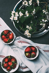 在碗毛巾和黑色茉莉花中熟红草莓的顶部视图图片