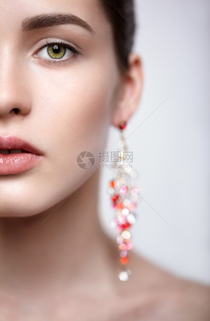 半面脸近身肖像青褐色年轻女人的红耳环图片