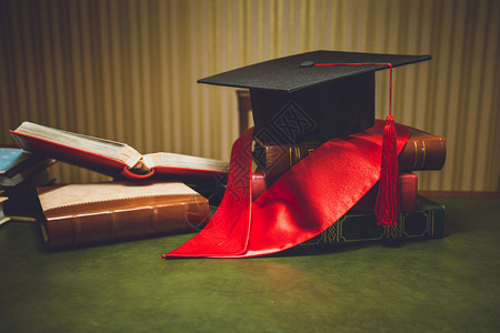 经典桌上红丝带和毕业帽的特图片