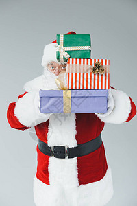 圣诞老人拿着礼物盒看着相机图片