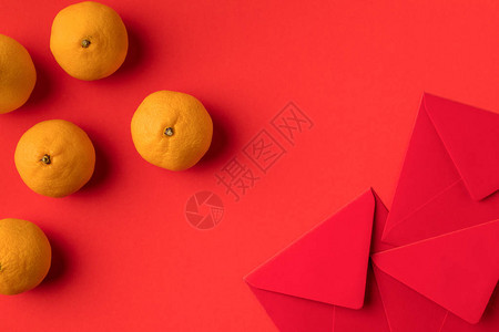 装饰节日红包和红色隔离的橘子的顶部视图图片