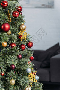 客厅里有红色和金色小玩意的圣诞树图片