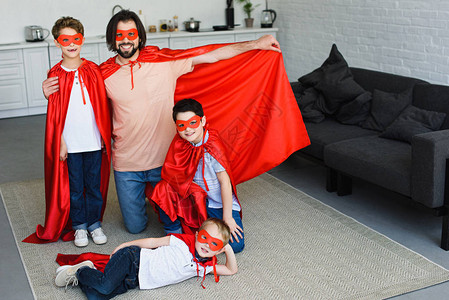 在家穿着红色超级英雄服装微笑着父亲图片