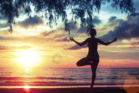 海与日落背景瑜伽与健康生活方式面的冥想女孩图片