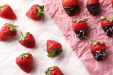 上面涂着巧克力的美味草莓在羊皮背景图片