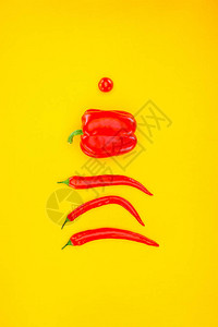 用黄色隔开的新鲜生辣椒和樱桃番茄的顶部视图图片