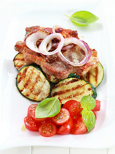 煎猪排配烤蔬菜和番茄沙拉图片