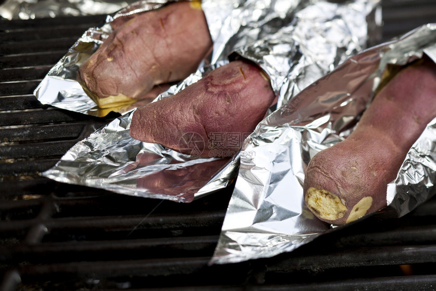 烤甜土豆在煤气烧烤炉图片
