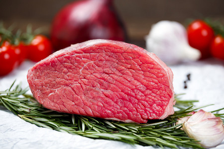 一块新鲜的肉牛肉板装饰着绿背景图片