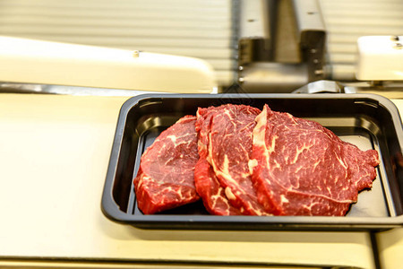 肉类加工厂牛肉被切成牛排就放在一图片
