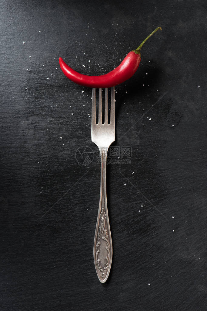 黑色表面红熟辣椒和叉子的顶部视图图片