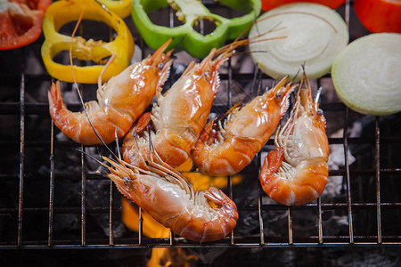 烤炉烧烤炉上烤的新鲜淡水虾配有背景图片