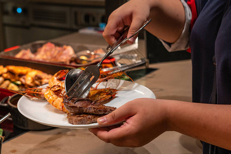 在自助餐柜台采虾和牛肉图片