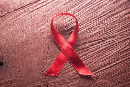 木制背景艾滋病上的红丝带图片