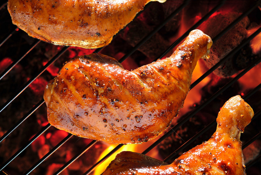 火焰状烤架上的烤鸡腿图片