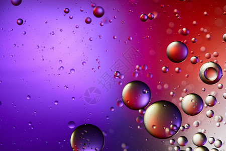来自混合水和油泡的创意紫色和红色抽象背景图片