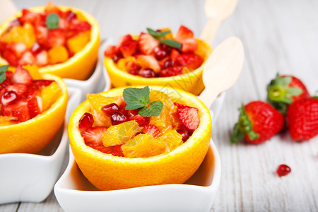 水果沙拉配石榴草莓和挖空的橙子图片