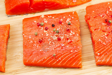新鲜野生红鲑鱼片上干红胡椒和海盐的特写水平照片图片