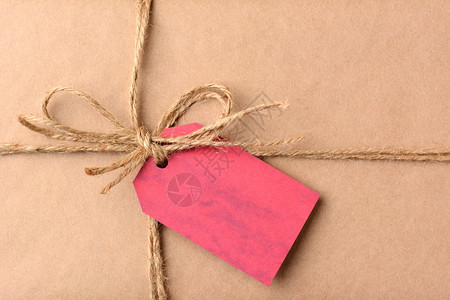 圣诞礼物上的礼物标签的特写包裹用普通的牛皮纸和麻线包裹红色标签为空图片