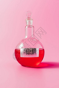粉红色上装有红色爱情药水的烧瓶特写镜头背景图片