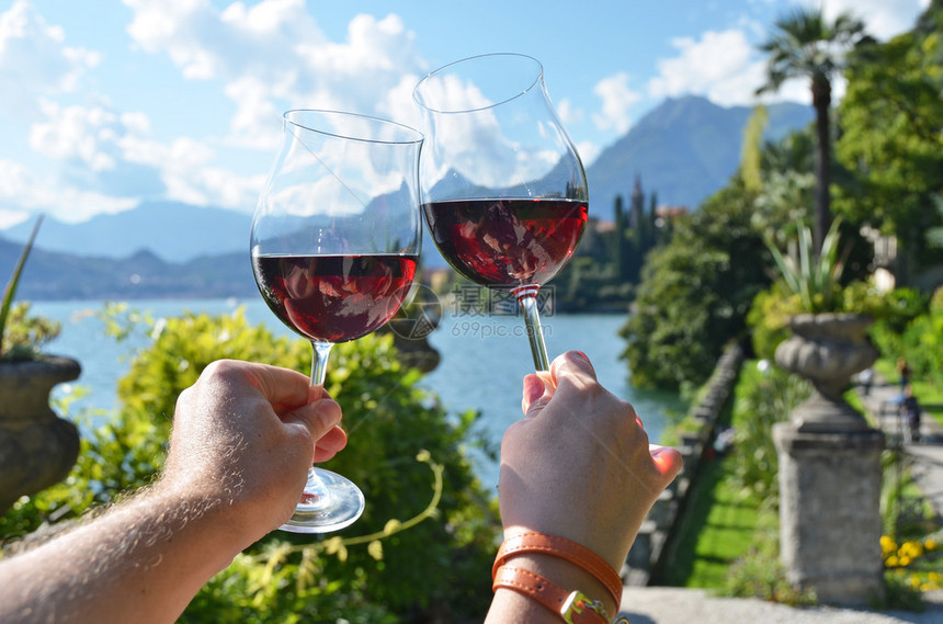 意大利科莫湖两杯葡萄酒手握着两图片