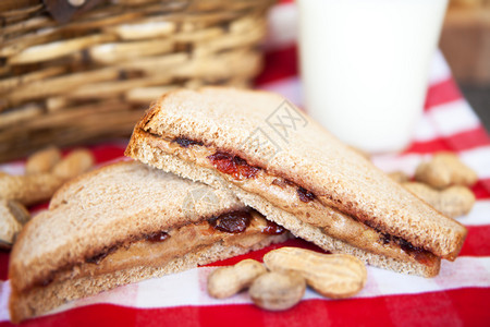 野餐午包括花生酱果冻三明治和红白格子图片