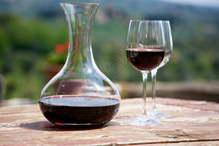 葡萄园的红酒和两个葡萄酒杯图片