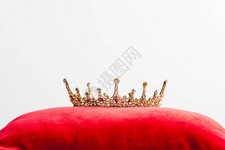 红色枕头上的皇冠用复制空间隔离在图片