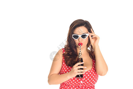 时尚加体型的女人在古老的太阳眼镜喝汽水图片