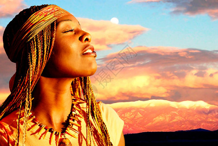 日落时美丽的非洲裔美国女人背景是群山图片