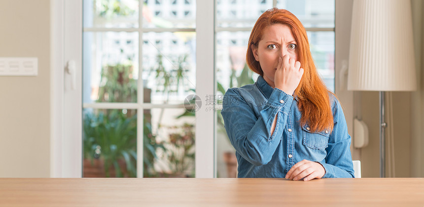 家里的红发女人闻到某种臭味和恶心难以忍受的气味图片