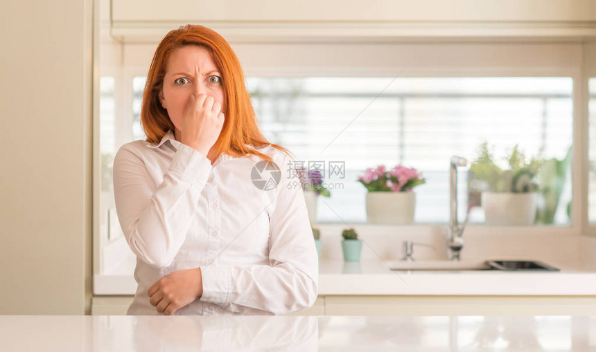 厨房的红发女人闻到一些臭味恶心不可容忍的气味图片