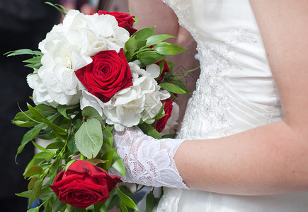 新娘手捧的红玫瑰白花婚礼花束图片